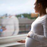 Pregnant woman looking out the window