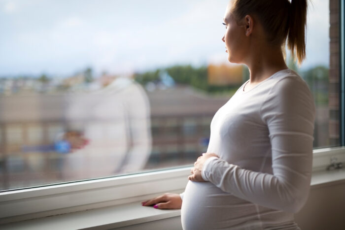 Pregnant woman looking out the window