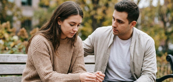 birthmother on a bench outside being comforted
